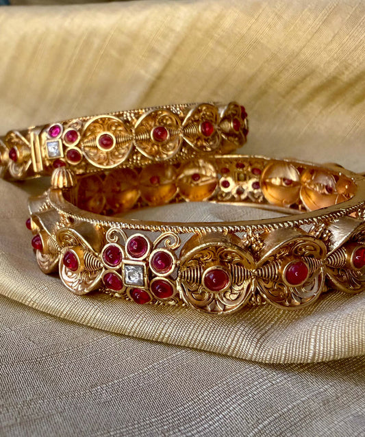 Antique gold kemp bangles with ruby stone detailing and hinged clasp, perfect for South Indian weddings and festive celebrations.